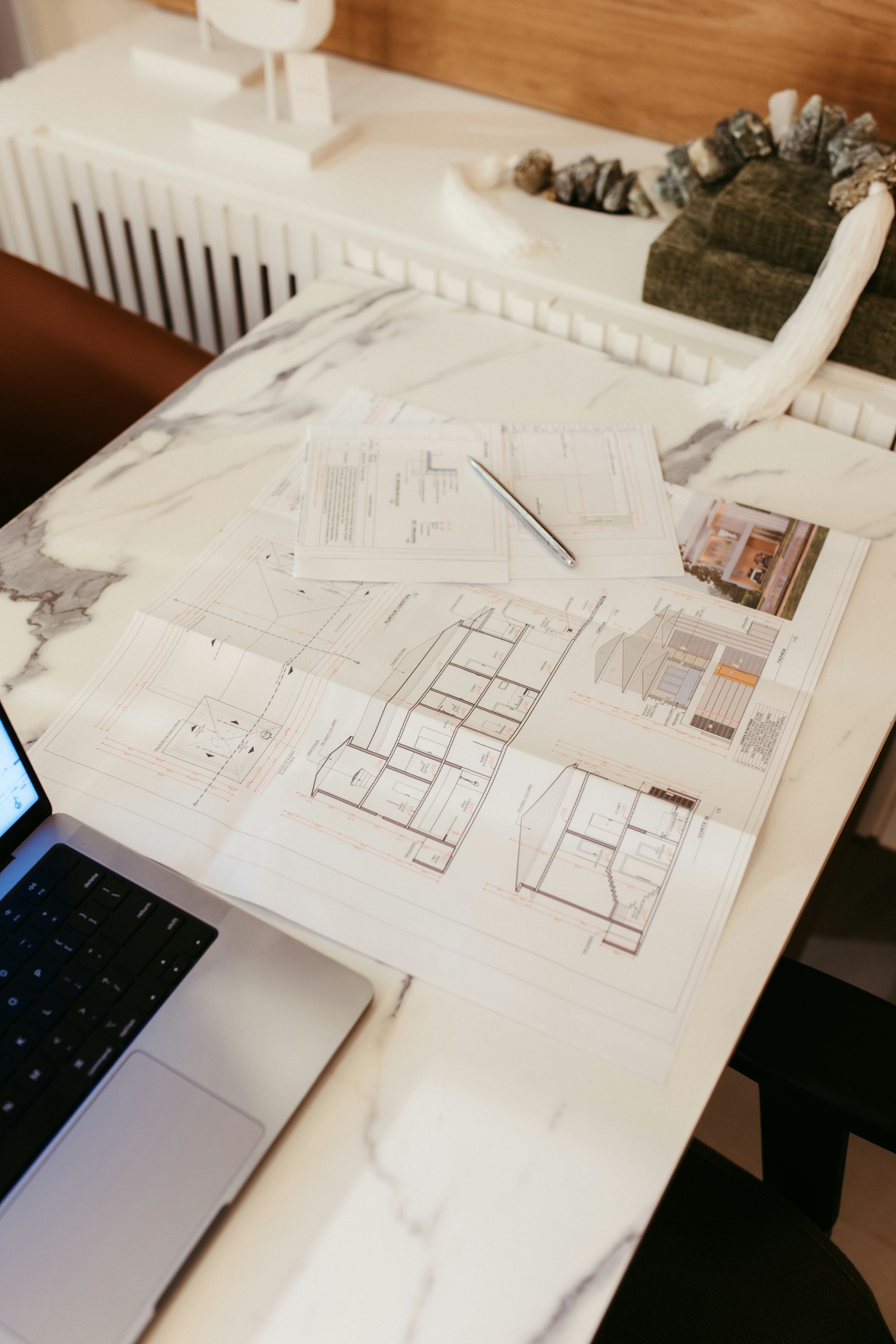 Planos técnicos y portátil sobre una mesa de trabajo